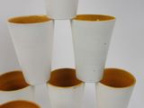 several white and yellow cups are stacked on top of each other