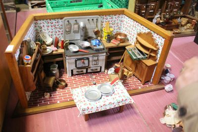 une cuisine miniature dans une maison de poupées, avec une table et des chaises