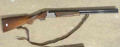 the rifle is laying on the floor next to a book