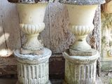two vases sitting next to each other on the sidewalk