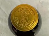 a bottle of wine with a gold lid on a table