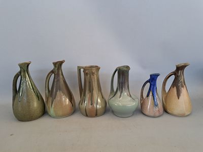 cinq vases de couleurs différentes alignés en rangée