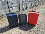 trois bagages posés les uns à côté des autres par terre