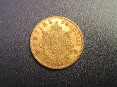 a close up of a gold coin on a black surface