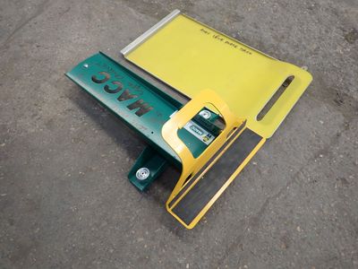 un panneau jaune et vert posé par terre à côté d'un parcmètre