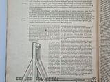 an open book with a drawing of a catapult on top of it
