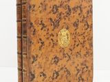 un livre marron avec un emblème doré sur la couverture