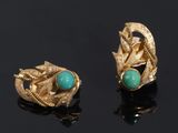 pair of gold and turquoise earrings on a black surface