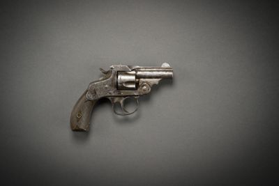 an old gun on a gray surface with a black background