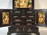 une commode noire ornée d'une peinture