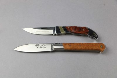 pair of knives on a table with a white table cloth