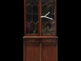 an antique mahogany china cabinet with glass doors