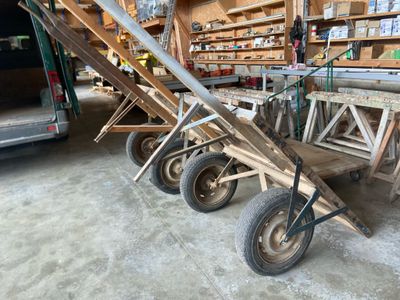 beaucoup de chaises en bois et un chariot dans un garage