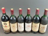 six bottles of wine lined up in a row on a table