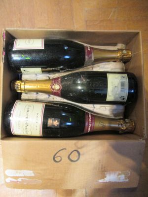 quatre bouteilles de vin dans un carton posé sur une table