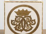 a white and gold vase with a gold crown on it