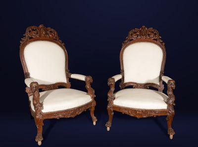 pair of antique carved wood chairs with white upholstered cushions