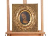 painting of a woman in a gold frame on a wooden easel