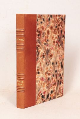 un vieux livre à la couverture brune posé sur une surface blanche