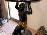 a statue of a boy holding a tray over his head