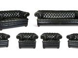 ensemble de quatre canapés et fauteuils en cuir noir sur fond blanc