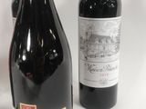two bottles of red wine sit next to each other on a table