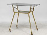 a gold metal and glass side table with a glass top
