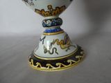 a white vase with a blue and yellow design on it