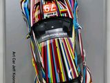 painting of a colorful car on display in a white frame