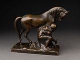 statue en bronze représentant un cheval et une femme assise sur un rocher