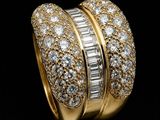 a close up of a gold and diamond ring on a black background