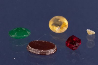 trois pierres précieuses de couleurs différentes sur un fond bleu
