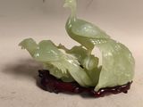une figurine représentant un oiseau perché sur un fruit