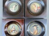 three plates with pictures of people on them on a wooden surface