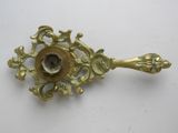a small brass object on a white surface