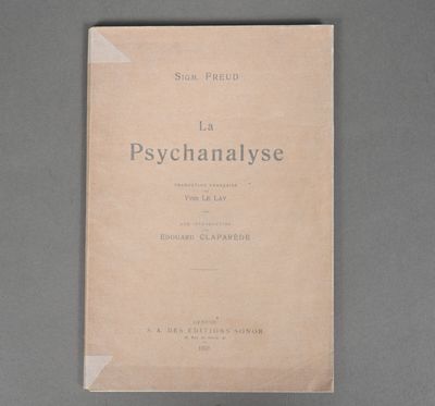 an old book sitting on top of a table next to a gray wall