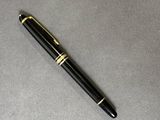 le stylo est posé sur la table, à côté de la feuille