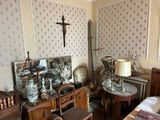 a room with a cross on the wall and a table with a lamp on it