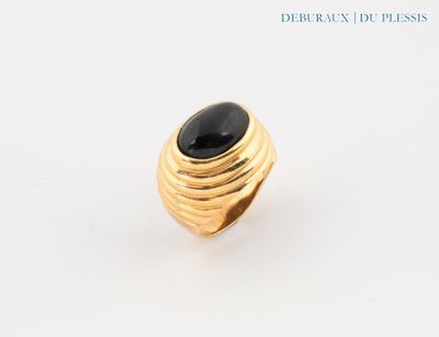 a close up of a gold ring with a black stone