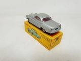 an old toy car sitting on top of a box on a white surface