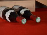 three bottles of wine sitting on a red table