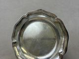 an antique silver plate on a table with a white background