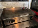 un plan de travail en acier inoxydable équipé d'une plaque de cuisson