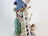 a figurine of a man and a woman climbing a ladder