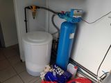 un réservoir d'adoucisseur d'eau bleu et un réservoir d'adoucisseur d'eau bleu dans un coin de la cuisine