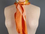 an orange silk scarf with a picture of a woman ' s face on it