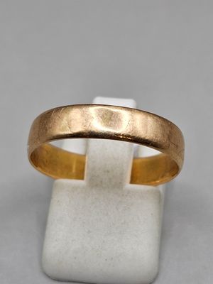 gros plan d'une bague en or sur une surface blanche