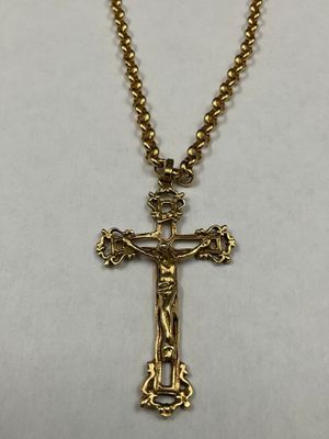 a close up of a cross on a necklace on a white surface