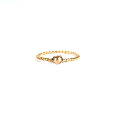 gros plan d'une bague en or sur fond blanc