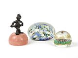 trois billes de verre et une figurine représentant un homme assis sur un rocher